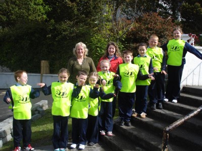 Páistí ó Scoil Náisiúnta Ghort a' Choirce agus a gcuid veisteanna úra garrantóireachta 'Beacha Beoga' á chaitheamh acu.